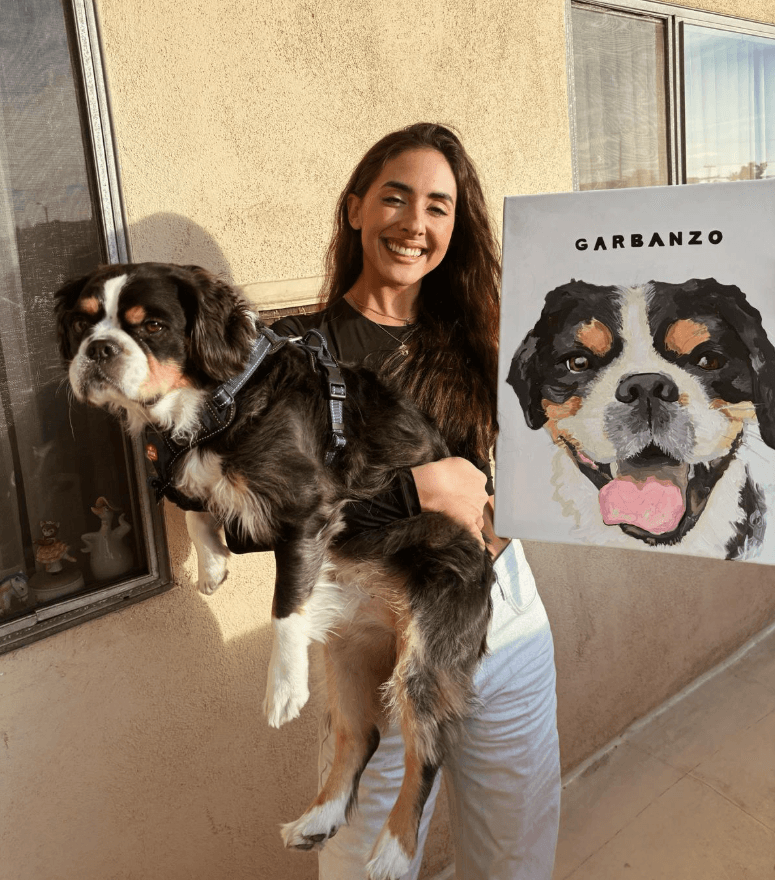 Hand-painted dog portrait shown alongside its subject