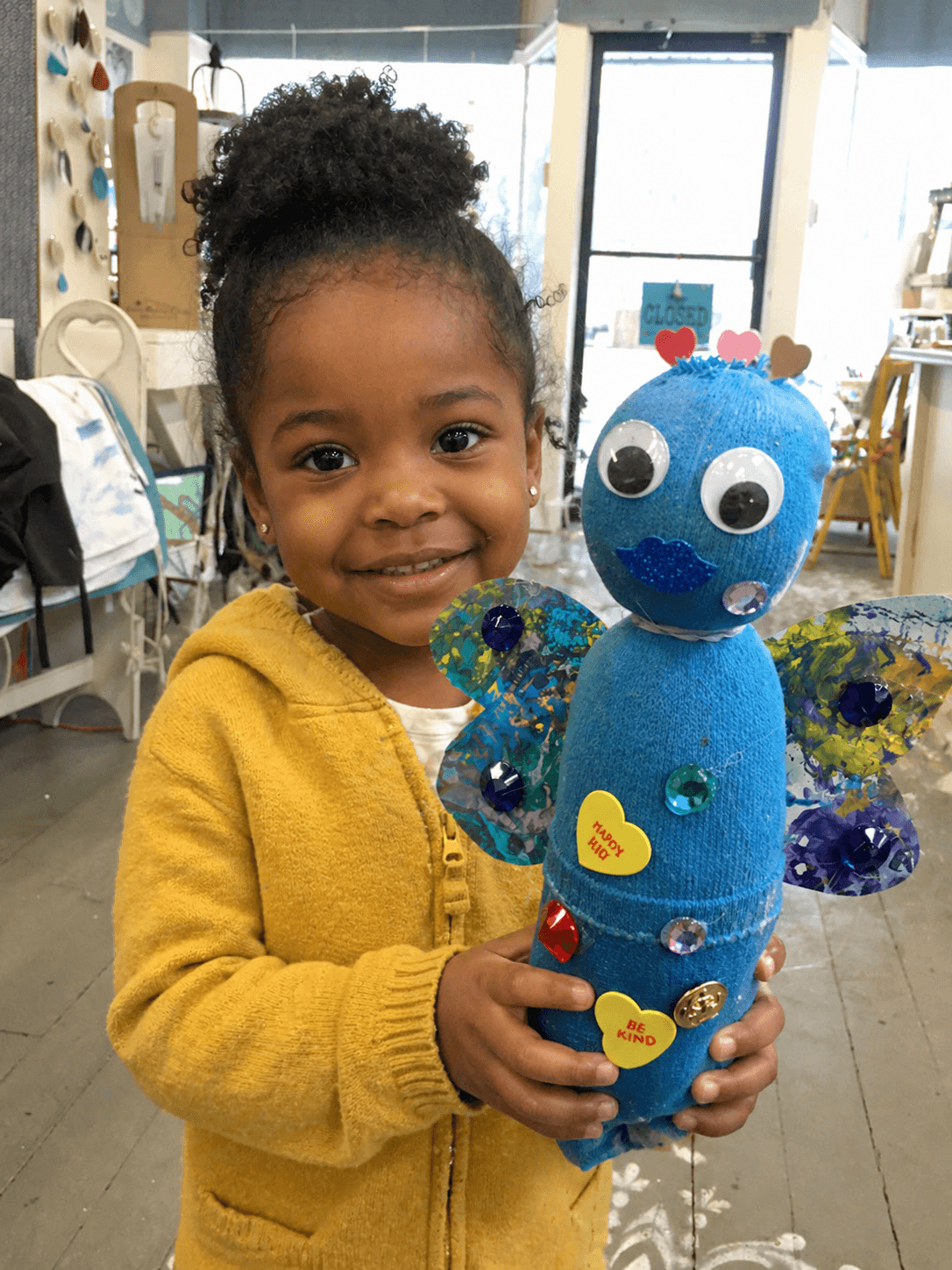 Young girl proudly holding her finished art project