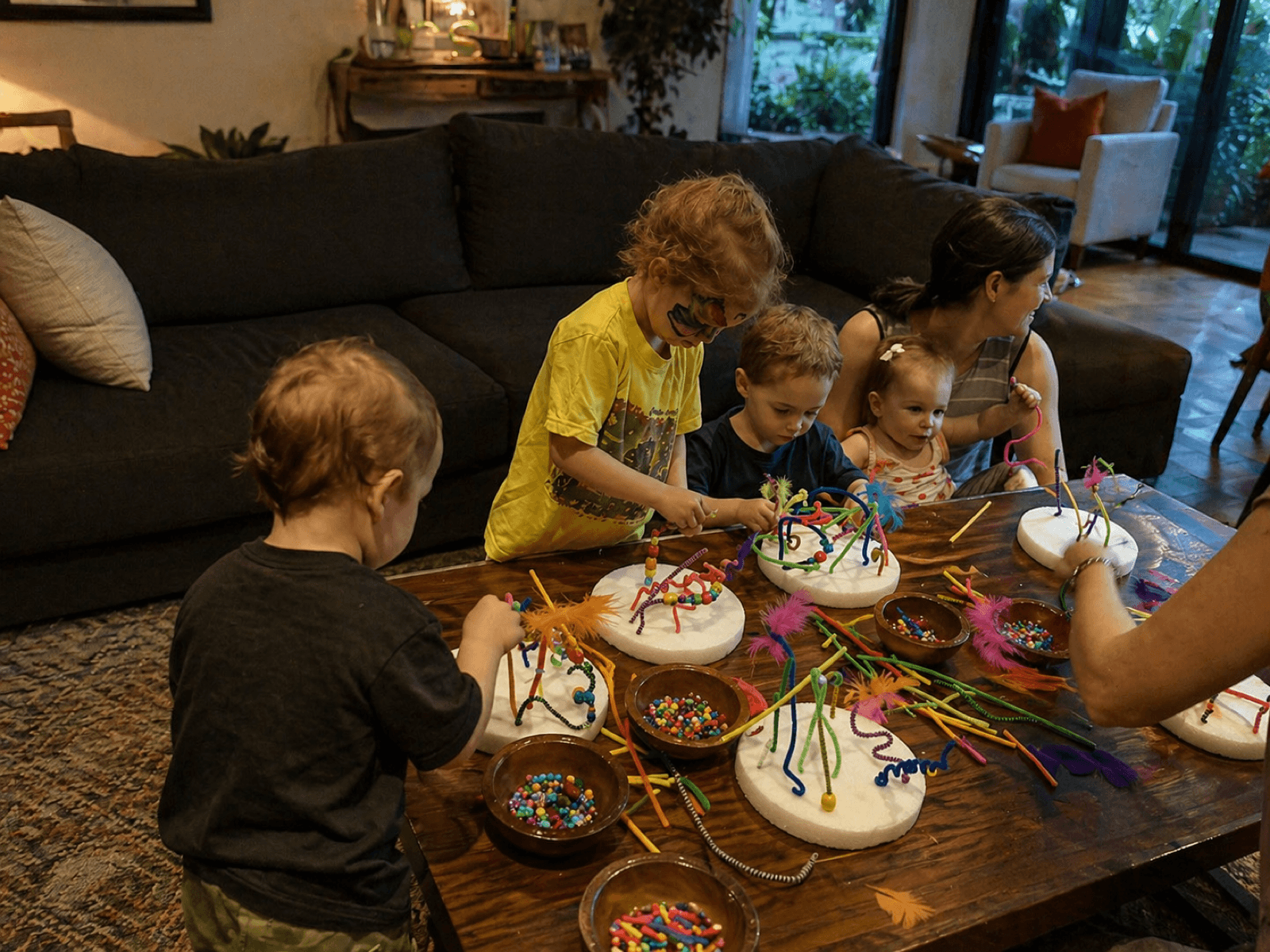 Kids outside at a Venice-themed party holding palm tree and beach paintings