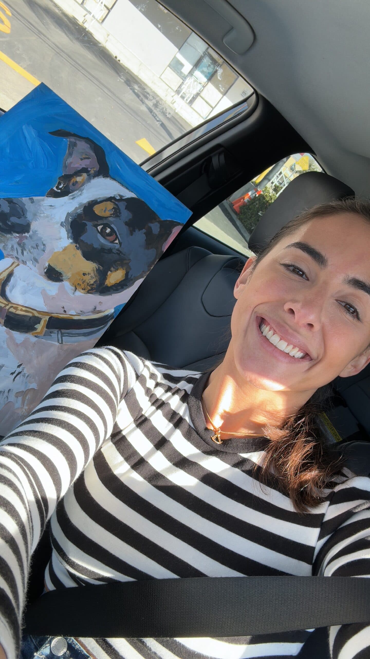 Elena Marmol smiling next to a freshly finished blue dog portrait